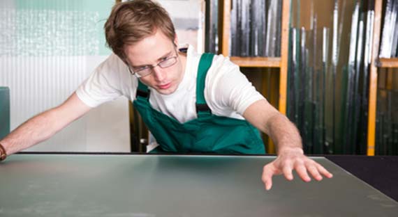 un artisan vitrier en train de travailler sur une vitre en verre