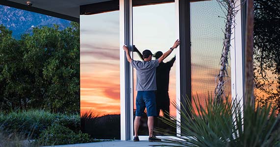 un vitrier en train de poser une vitre en verre